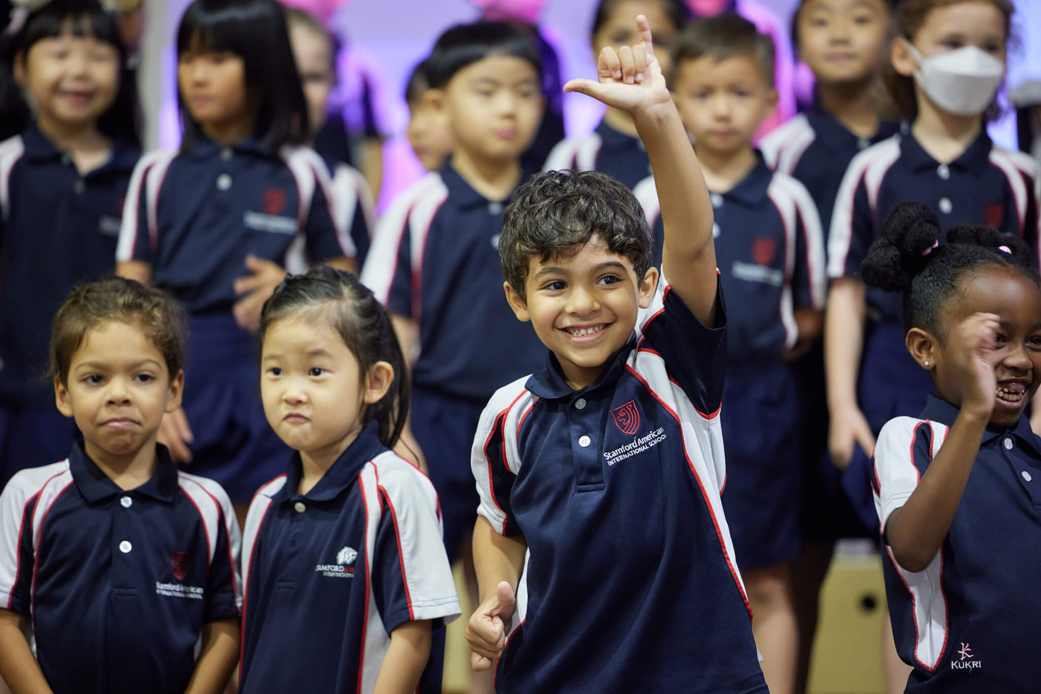 a group of students and one student boy putting his hand up